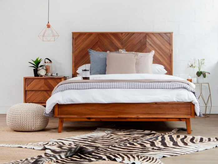 Front view of acacia wooden bed and pedestal  on zebra hide